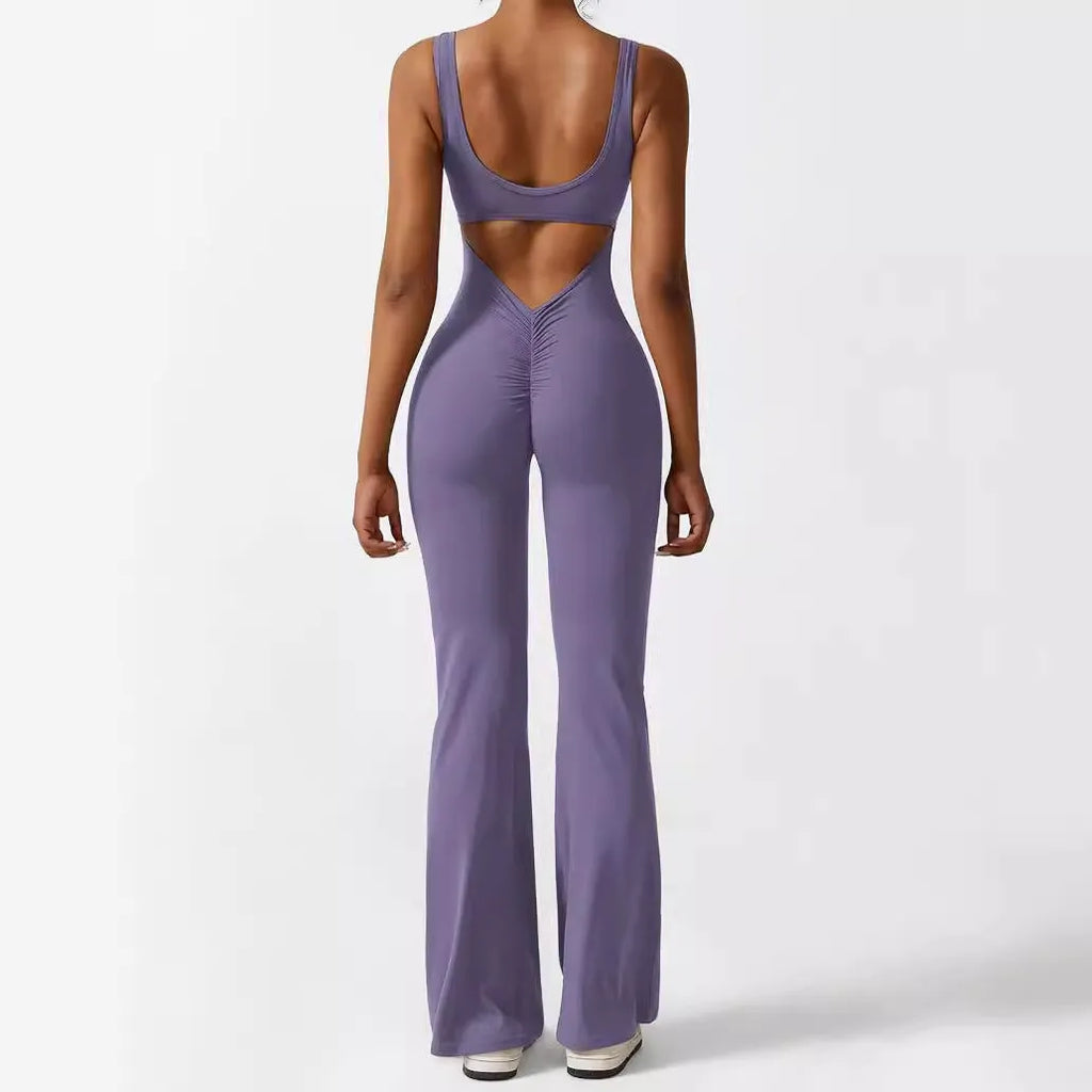 Woman wearing a sleeveless army green flare jumpsuit for yoga, showcasing the fashionable waist and trouser length.