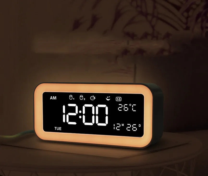 Blue rectangular LED atmosphere light alarm clock with digital display on a desk.