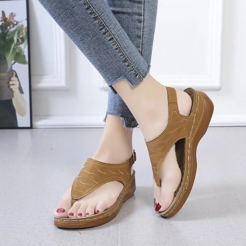 Women's black casual wedge heel flip flop sandals showing adjustable back buckle strap and solid colour design.