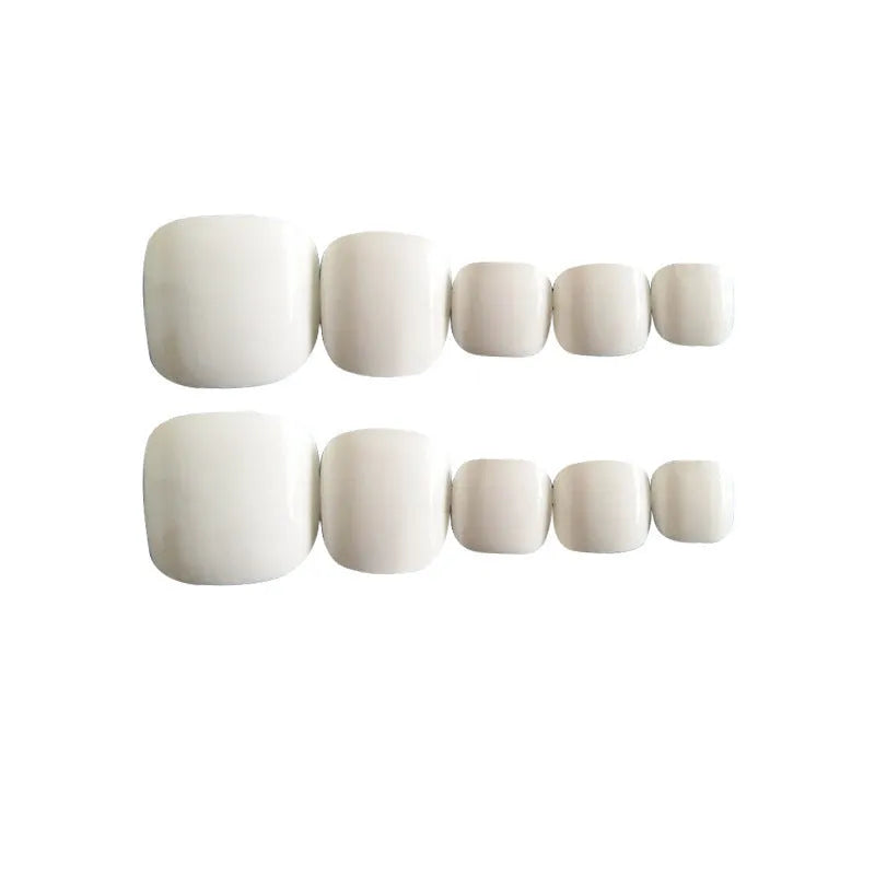 Set of white false toe nails with starry sky pattern, arranged on a clear background.