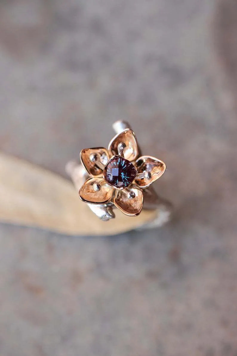 Silver and rose gold two-tone floral design alloy ring on a geometric band.