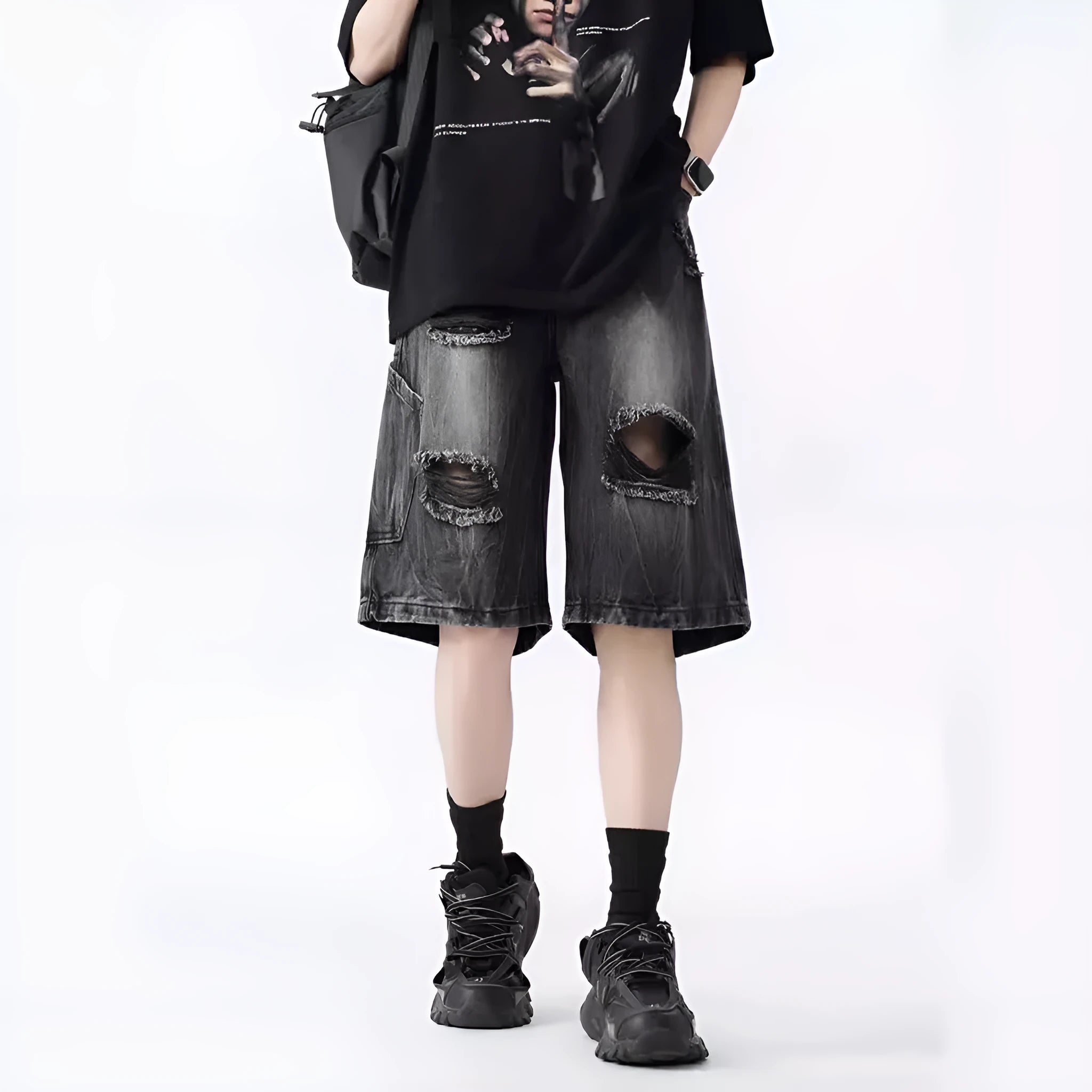 Man's loose-fit ripped denim shorts in washed black showing distressed details and retro styling