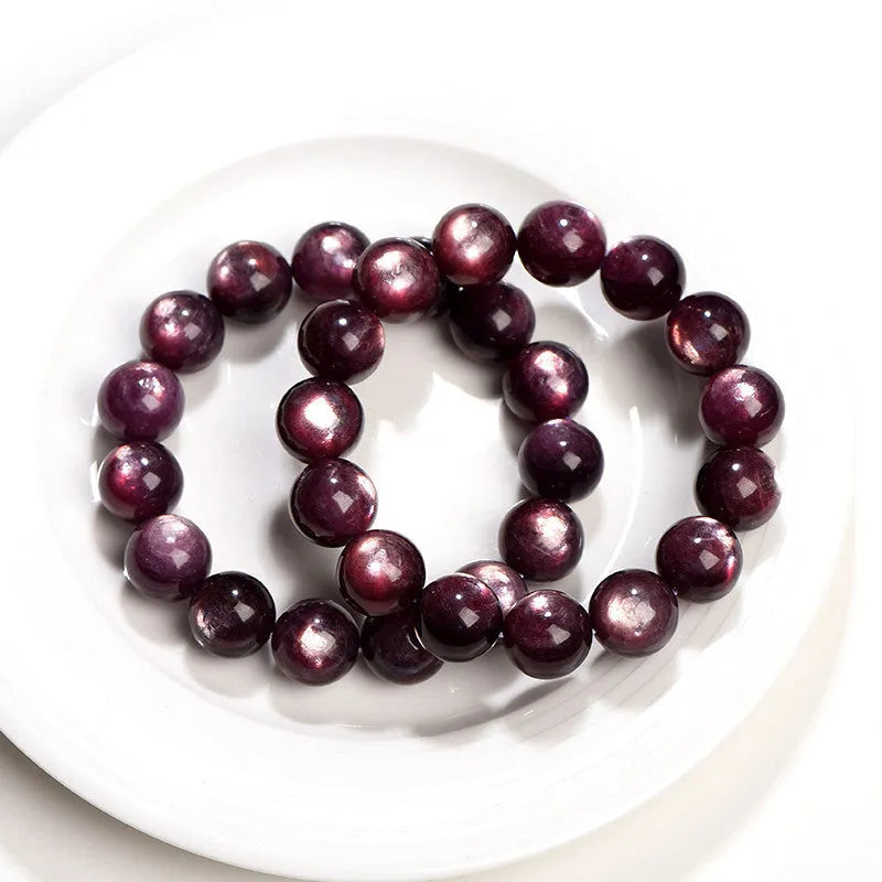 Natural purple lepidolite round bead crystal bracelet showing polished beads on a wrist.