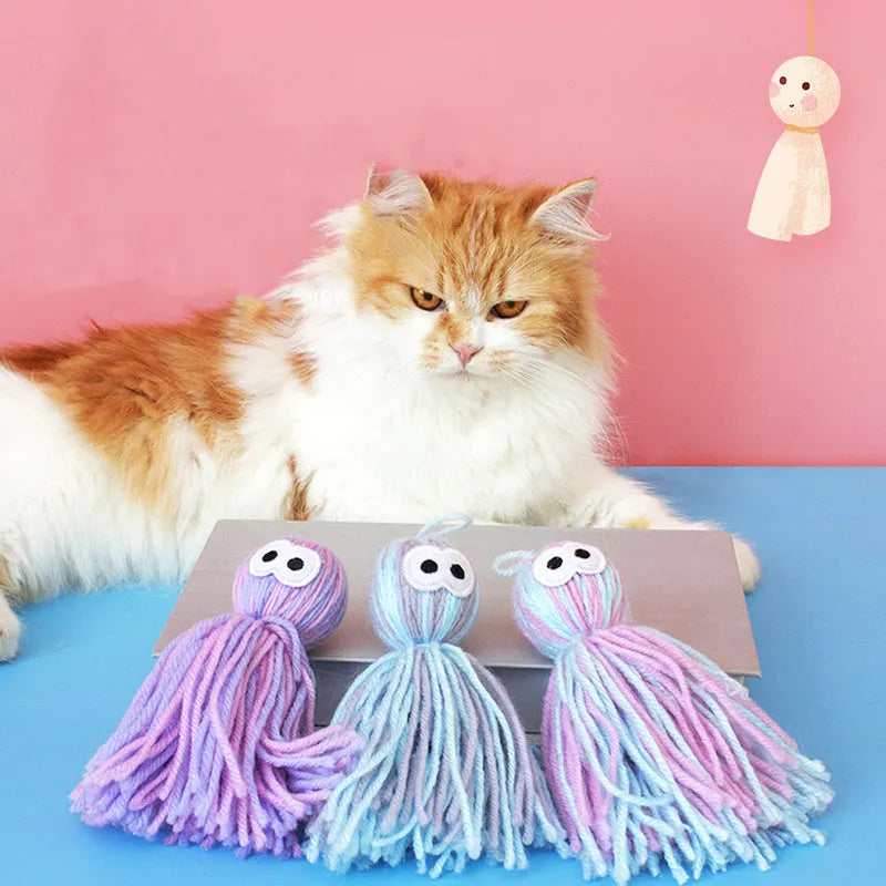 Blue grey wool cat toy with teaser stick hanging from furniture