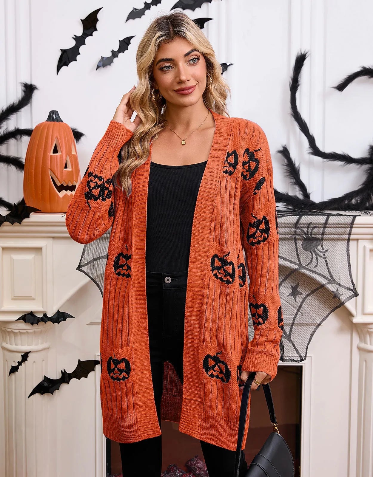 Women's black knitted cardigan with an orange pumpkin head jacquard pattern and regular sleeves.