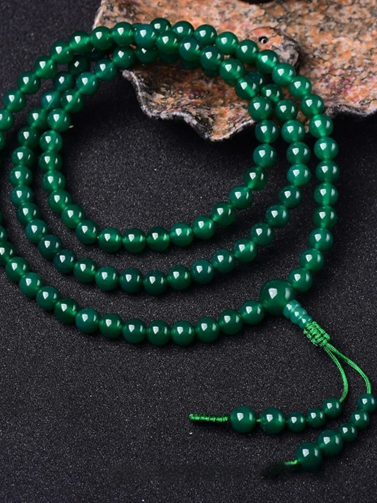 Handmade green agate bracelet with a detailed thangka pendant and multi-circle bead design.