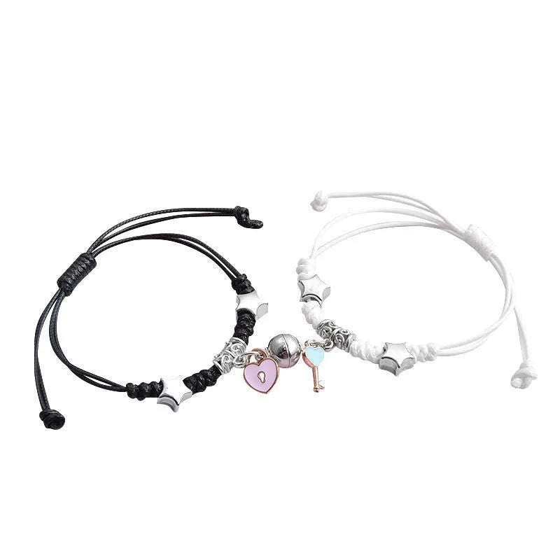 Pair of magnet couple bracelets with suction clasp on wrist, showing alloy designs like crown and love lock.
