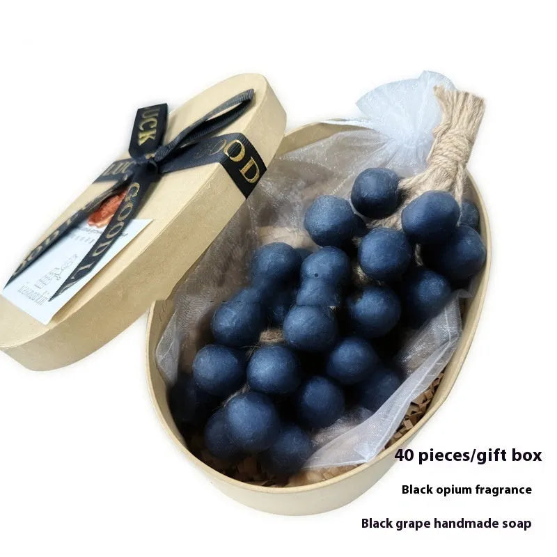 Handmade grape soap bars in black, green, and purple grape scents alongside litchi soap, with gift box and mesh bag packaging