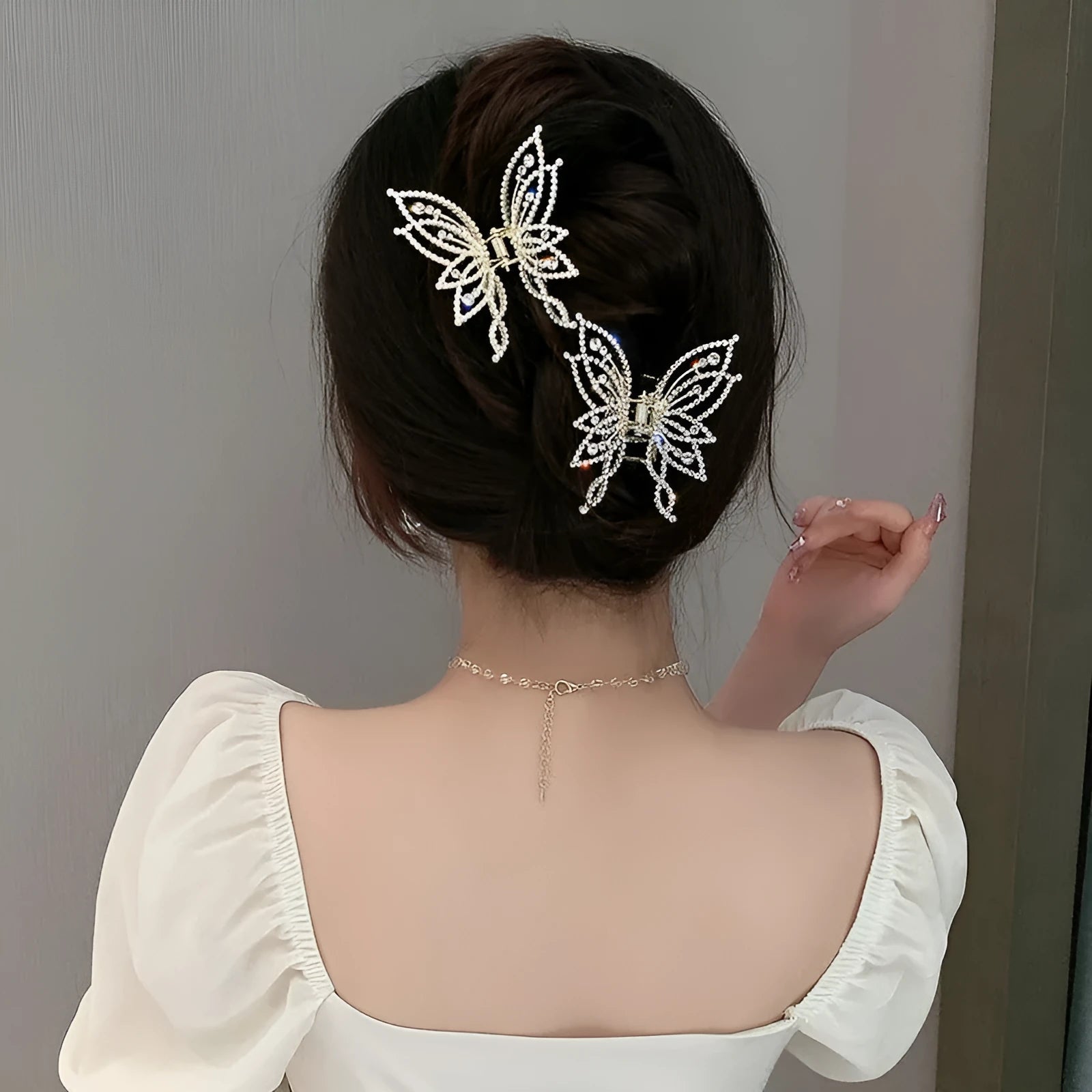 Butterfly-shaped alloy hair clip barrette for women, shown in rhinestone and pearl style options.