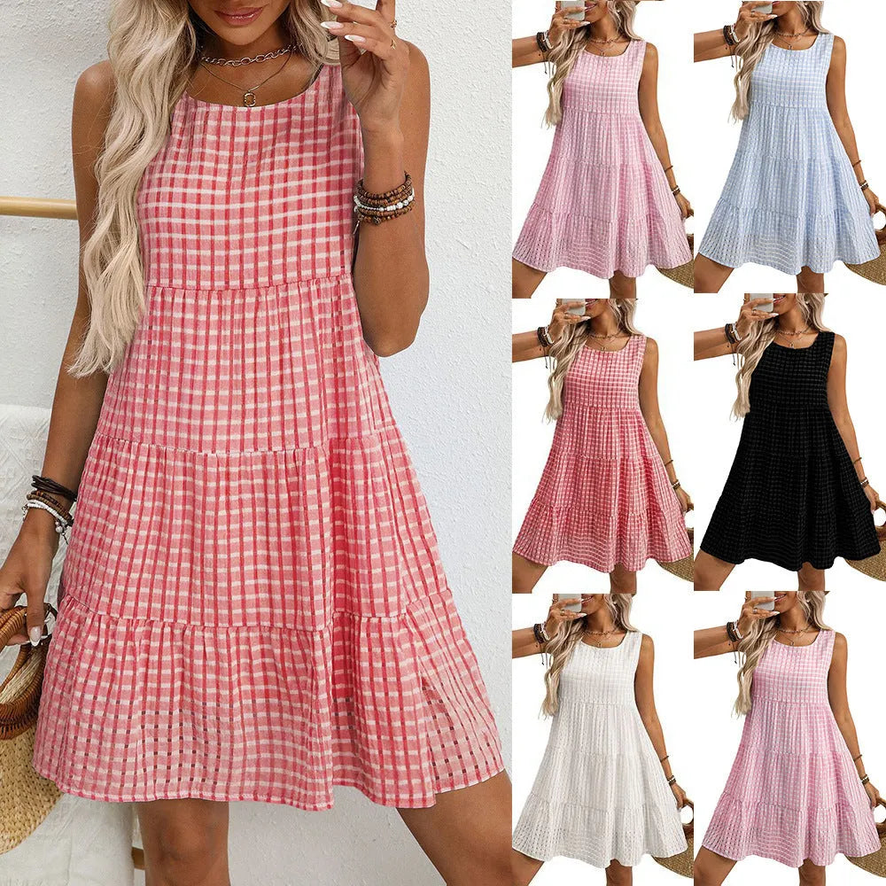 A woman wearing a light blue sleeveless plaid dress with an oversized swing skirt and high waist.