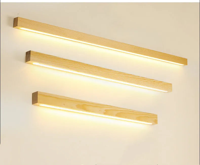 Walnut coloured log strip wall lamp with a square wood and acrylic profile mounted on a wall.