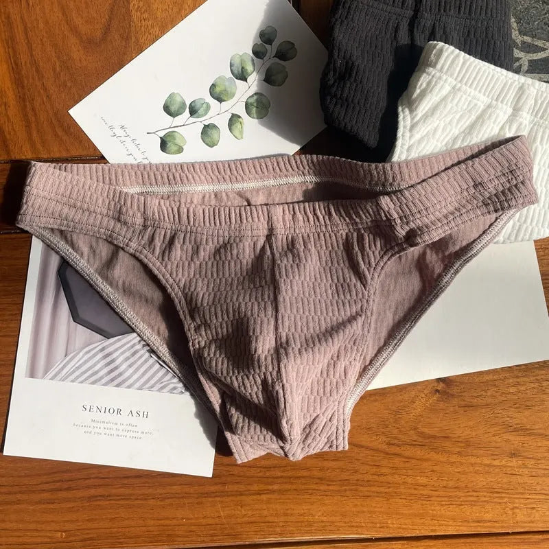 Men's solid colour cotton briefs with mid waist and triangle style in apricot black and skin colour.