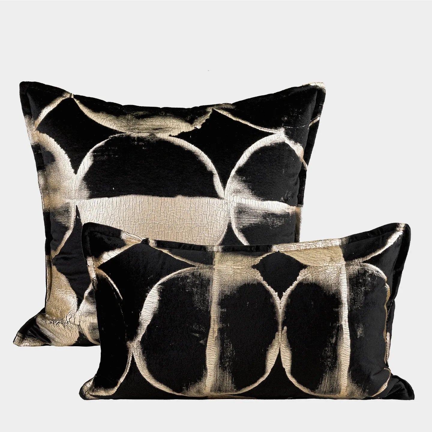 Black and gold abstract pattern flannel decorative cushion on a grey sofa.