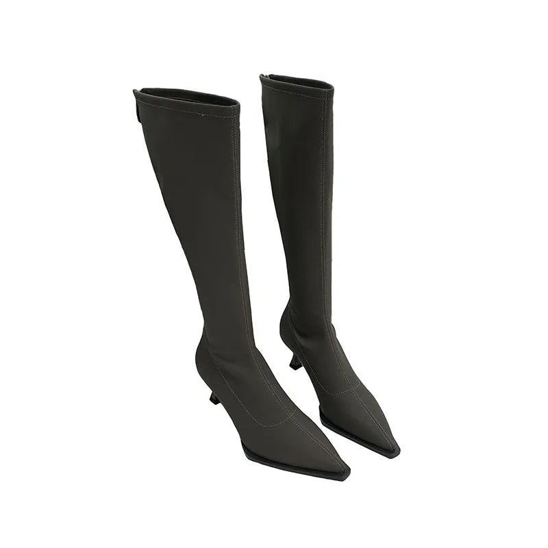 Black women's pointed toe stiletto heel boots with a back zipper, shown below the knee.