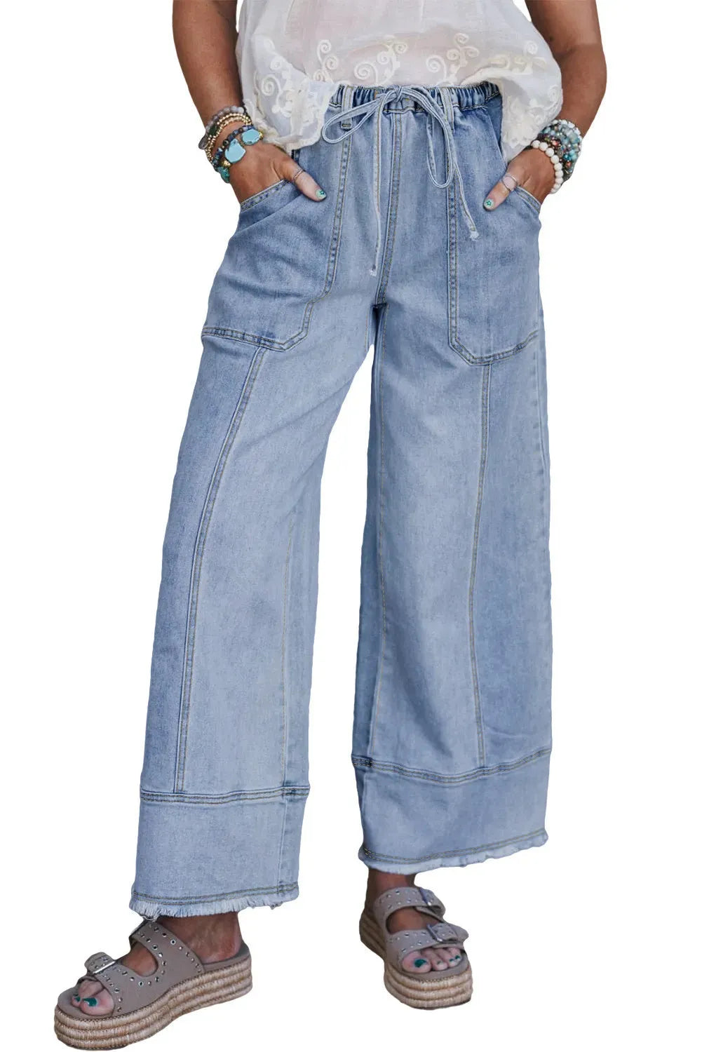 Beau blue wide leg denim trousers with drawstring waist and raw hem on a hanger