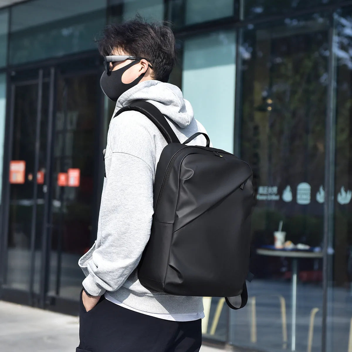 Waterproof PU leather backpack in black, blue or grey showing simple design and sewing thread detailing