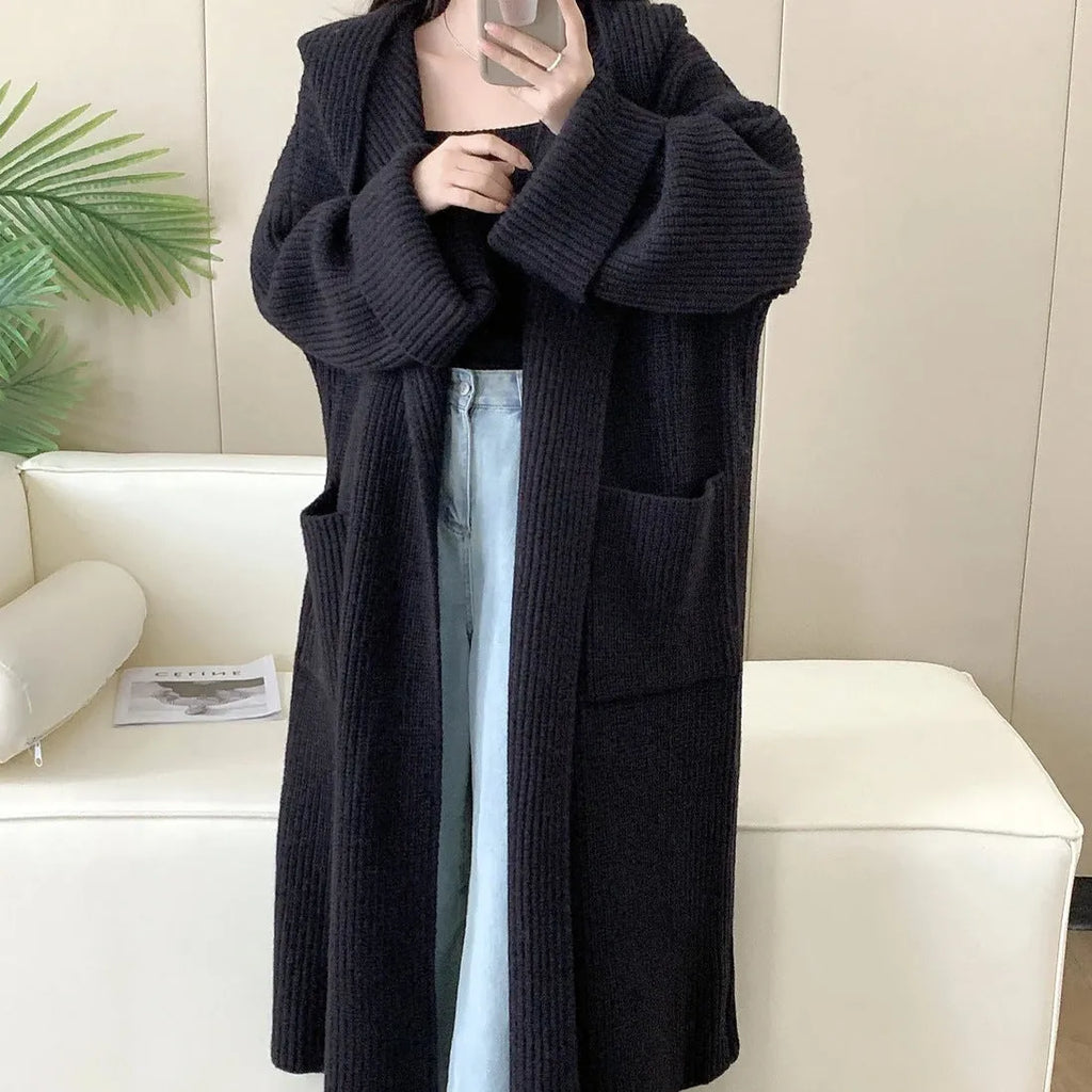 Loose hooded acrylic cardigan coat for women in beige, showing long length and raglan sleeves.