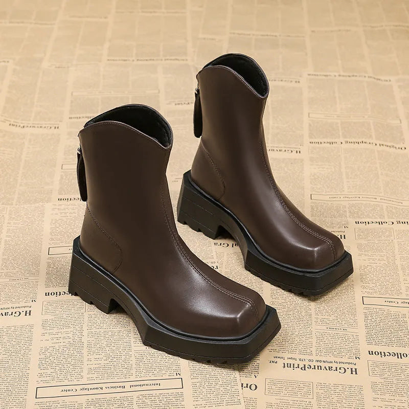 Women's black platform Martin boots with square toe, chunky heel, and back zipper on a white background.