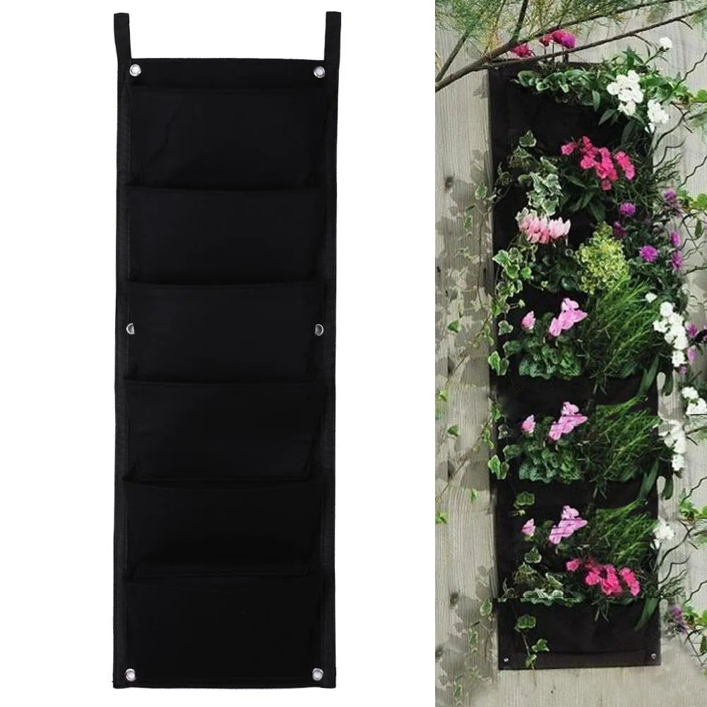Green recycled felt vertical wall planter with multiple planting pockets hung on a wooden fence.