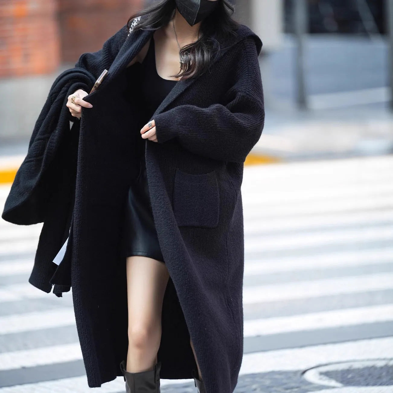 Long grey knitted women's cardigan trench coat with a hood and long sleeves.