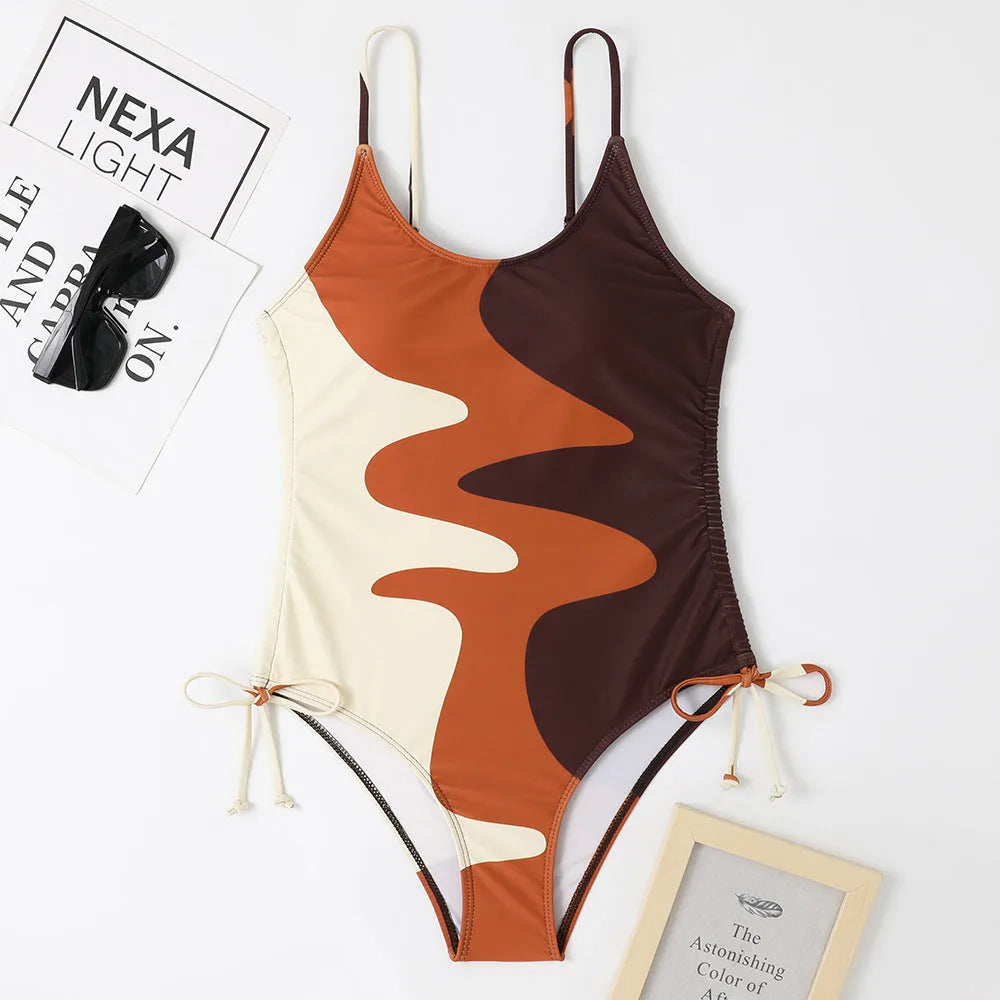Women's sleeveless backless one-piece swimsuit in a striped pattern, shown in blue.