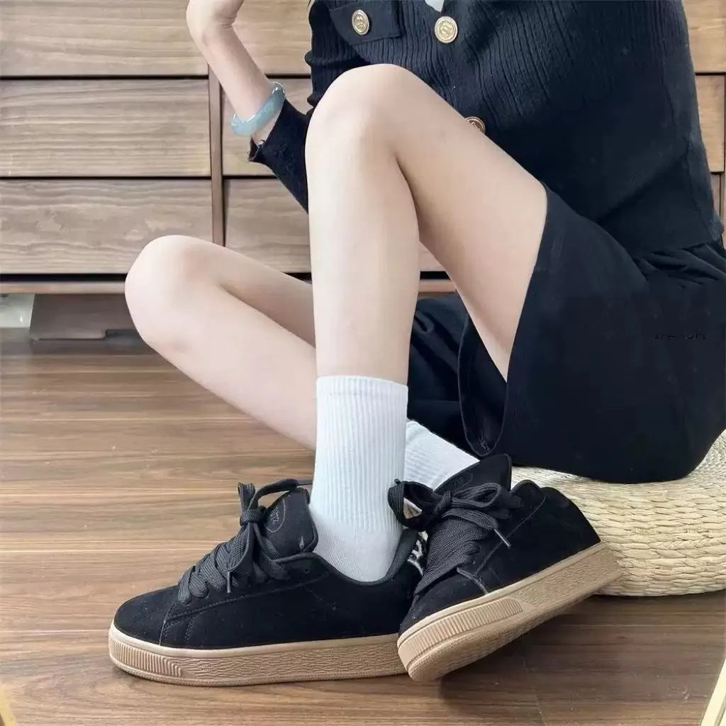 Black retro-style low-top lace-up sneakers with a round toe and waterproof platform sole.