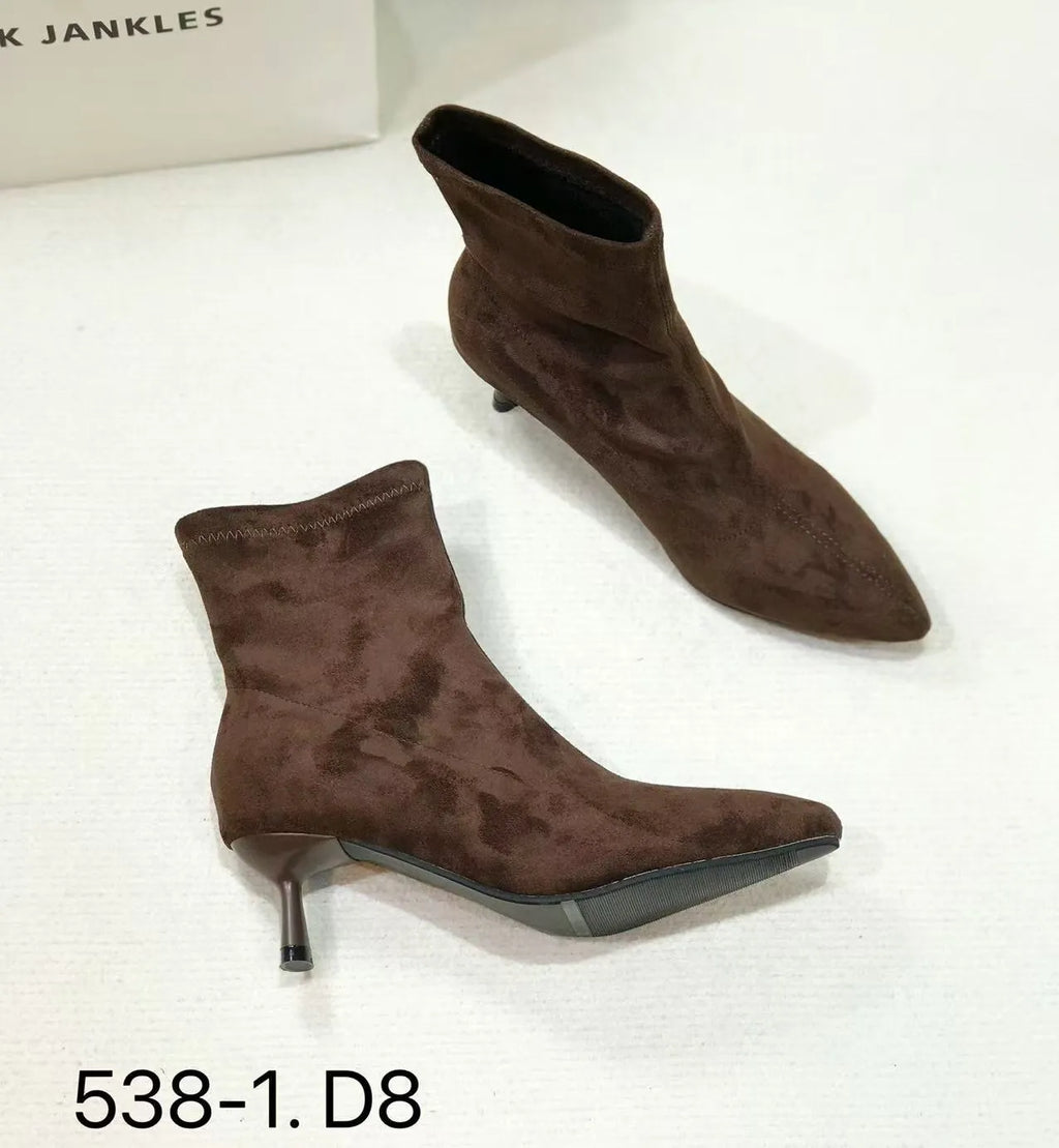 Black pointed toe ankle boots with a stiletto heel on a plain background.