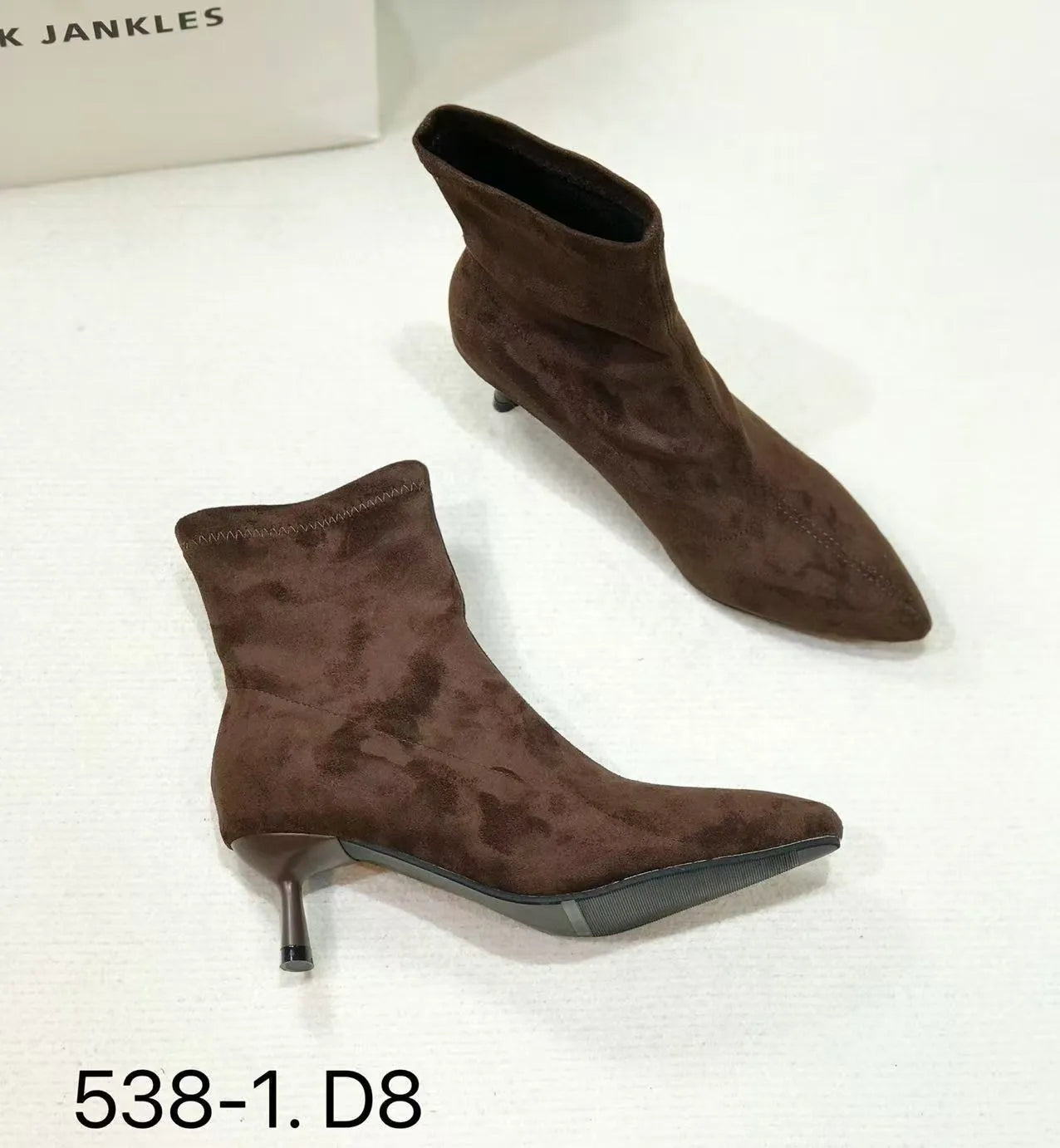 Black pointed toe ankle boots with a stiletto heel on a plain background.