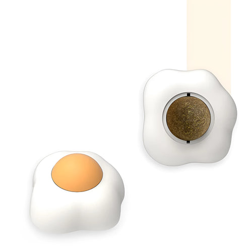 Soft plush catnip ball toy with suction cup mounted on a wall, shown in fried egg and poached egg shapes.