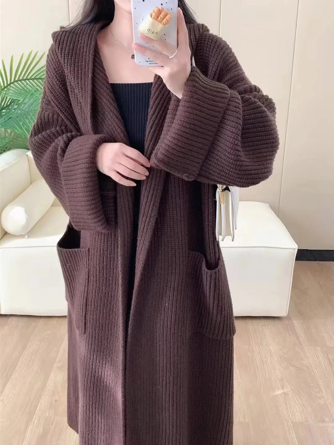 Loose hooded acrylic cardigan coat for women in beige, showing long length and raglan sleeves.