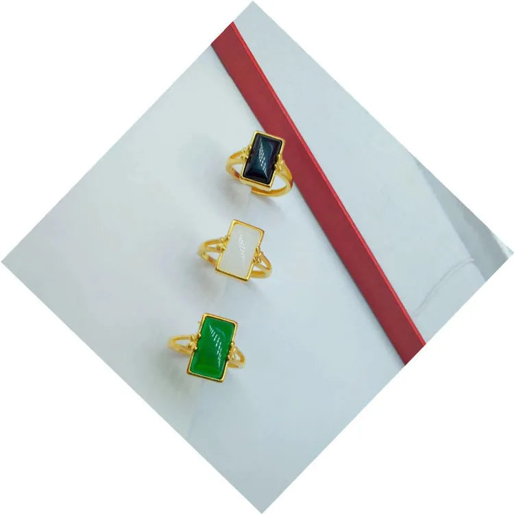 Adjustable gold-plated brass ring with a long coloured gemstone in green, white, or black.