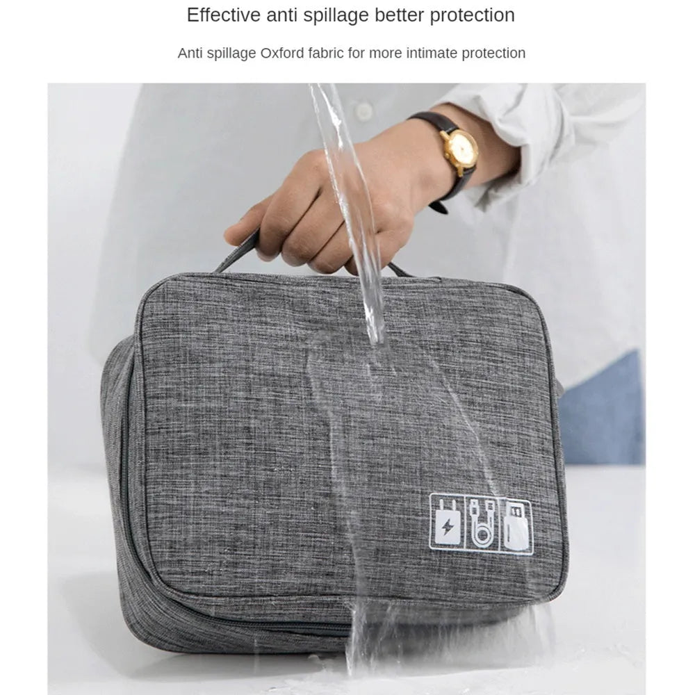 Black waterproof travel cable organiser bag open to show removable dividers and mesh pockets for electronics.