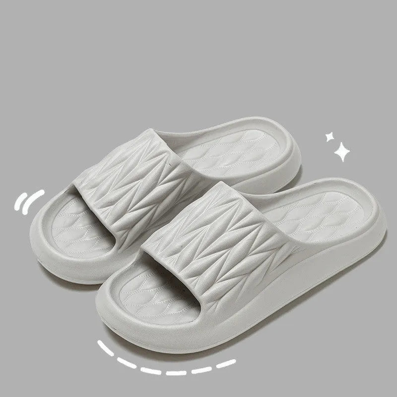 Pair of leaf-textured EVA indoor slippers on a solid background, showing non-slip sole.