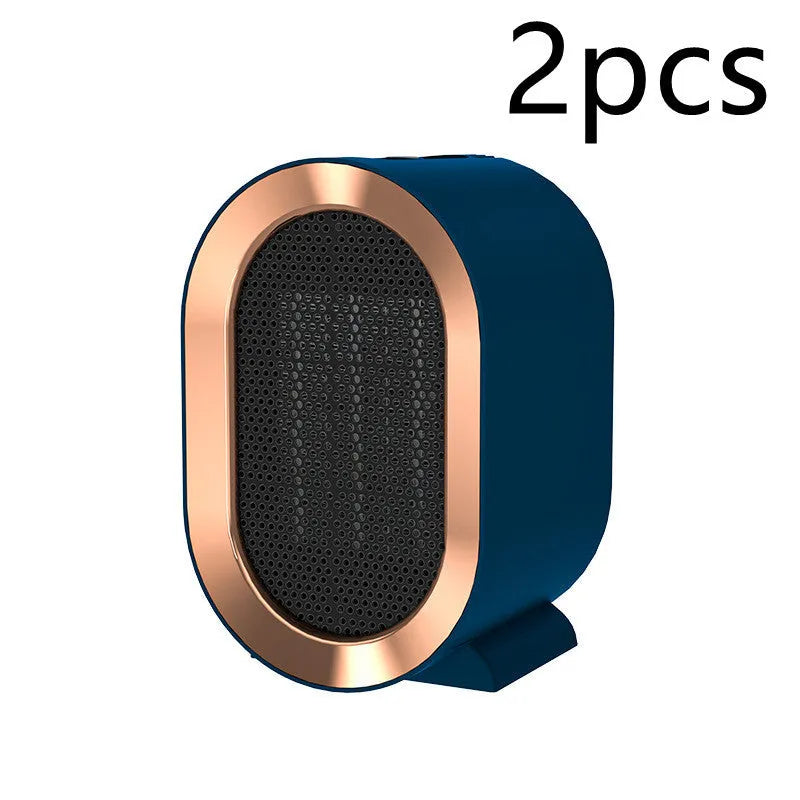 Compact black desktop electric ceramic fan heater with mechanical controls on a wooden desk