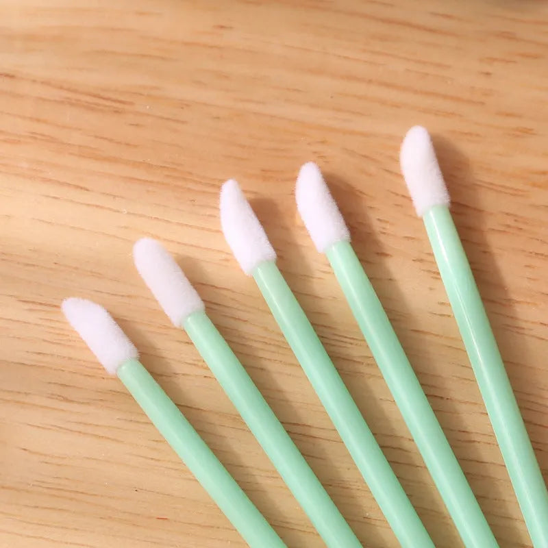 Disposable lip brush applicators with flocked heads in multiple handle colours on white background