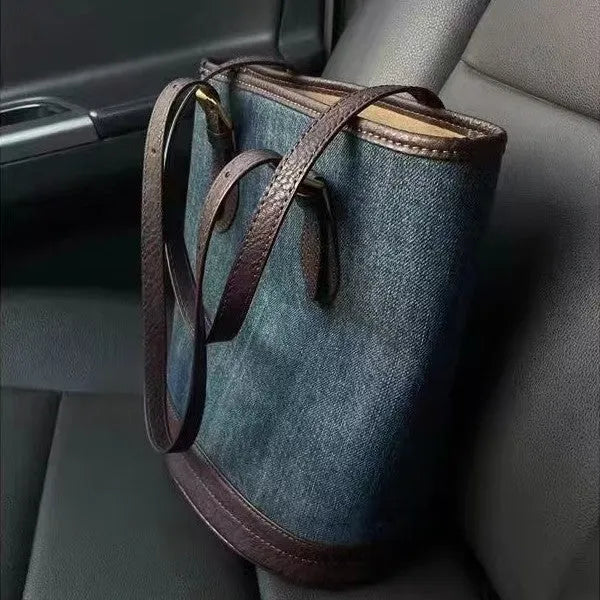 Large denim patchwork bucket handbag showing adjustable strap and retro styling