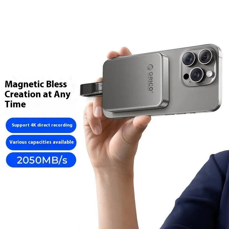 Grey magnetic mobile solid state drive with C to C cable and magnetic ring on a dark surface.