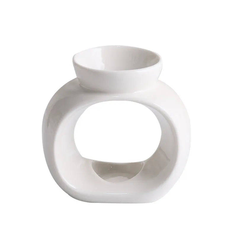 White ceramic Nordic-style aromatherapy stove ornament on a wooden surface.