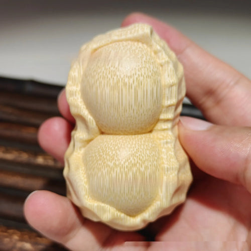 Carved solid bamboo peanut ornament in a modern simplicity style on a plain background.
