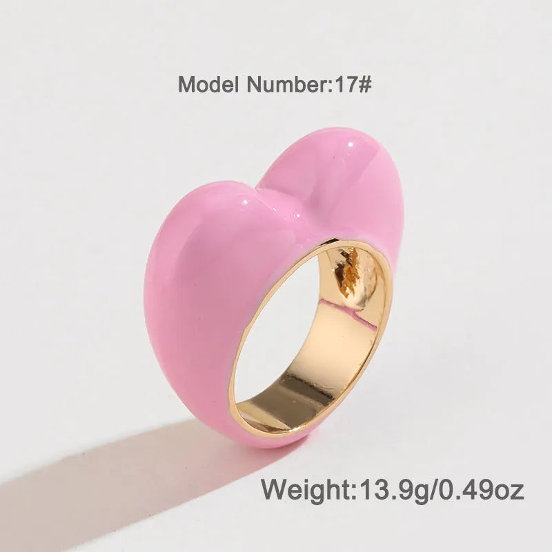 Close-up of a heart-shaped ring with a raised red enamel heart on a metallic band.