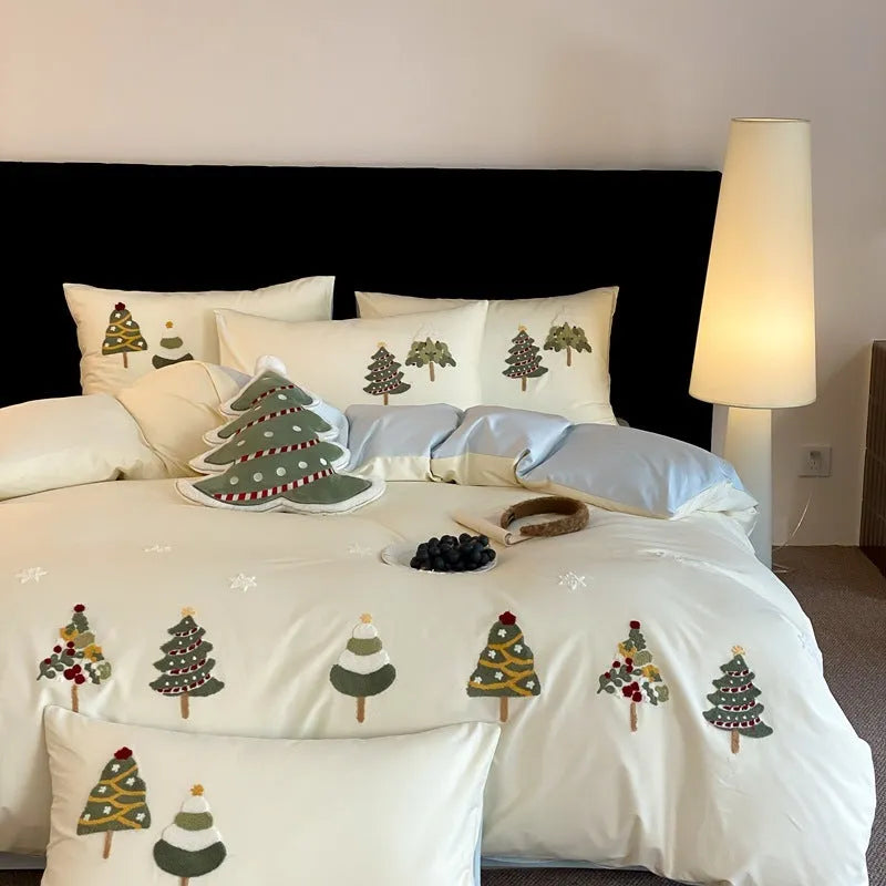 Four-piece cotton bedding set with Christmas tree towel embroidery pattern showing duvet cover, bed sheet, and pillowcases