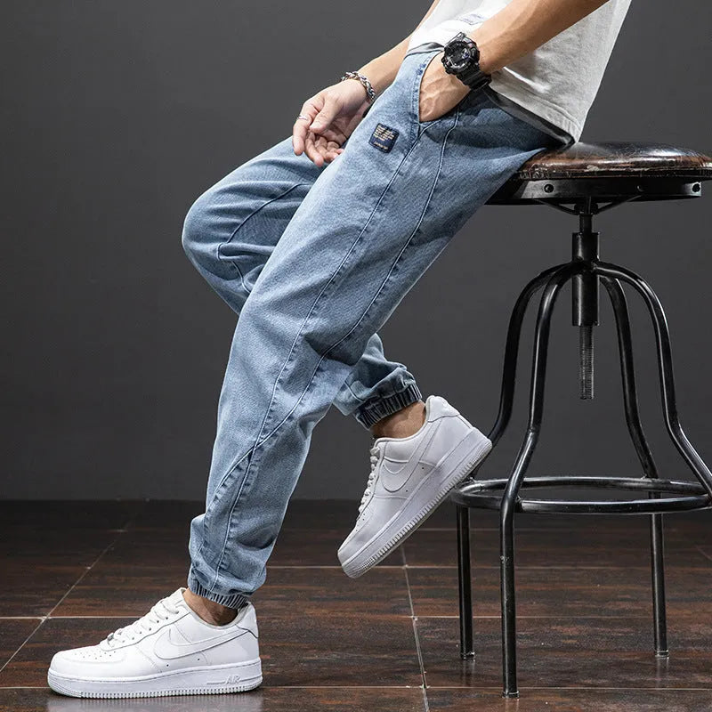 Men's loose-fit light blue cargo jeans with pockets and straight leg on a neutral background.