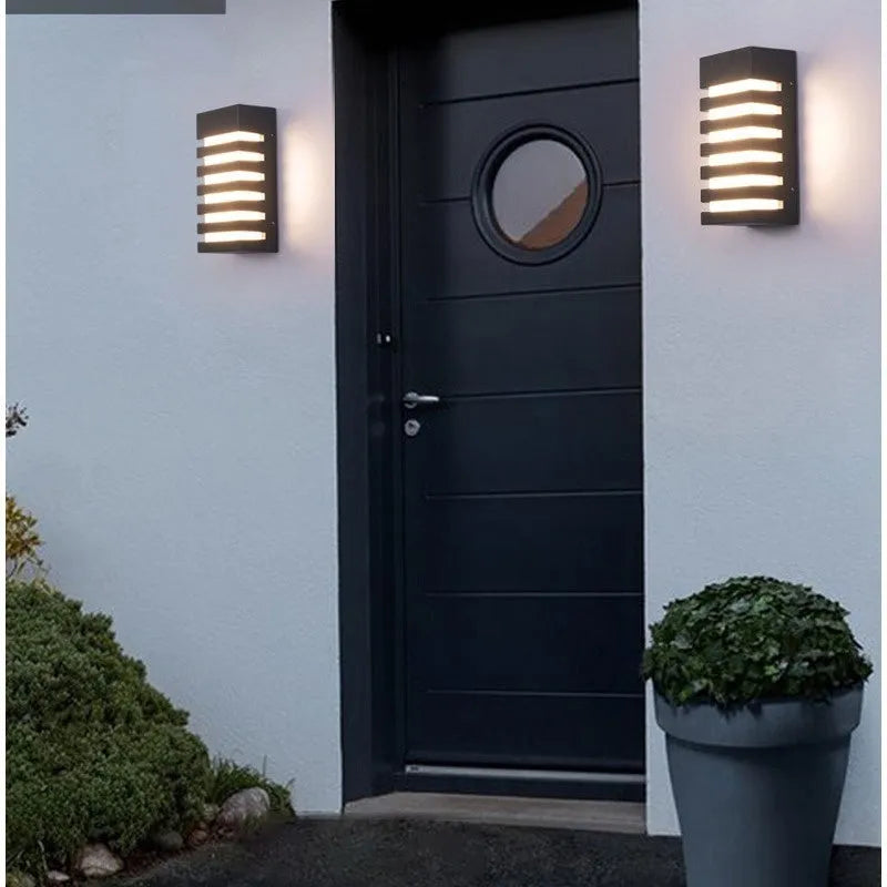 Modern minimalist outdoor wall lamp with aluminium shell, shown mounted on an exterior wall.