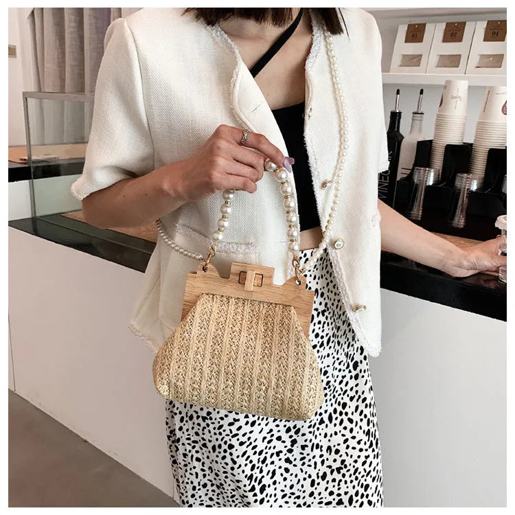 Women's straw shoulder bag with pearl chain strap in beige colour showing organised interior with compartments