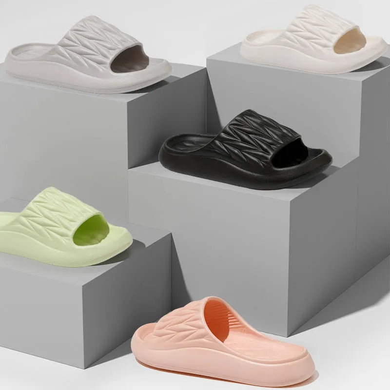 Pair of leaf-textured EVA indoor slippers on a solid background, showing non-slip sole.