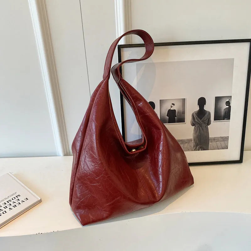 Soft leather shoulder bag in black with sandwich pocket design and shoulder strap