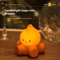 Silicone cartoon fire pile night light with yellow LED illumination on a bedside table.