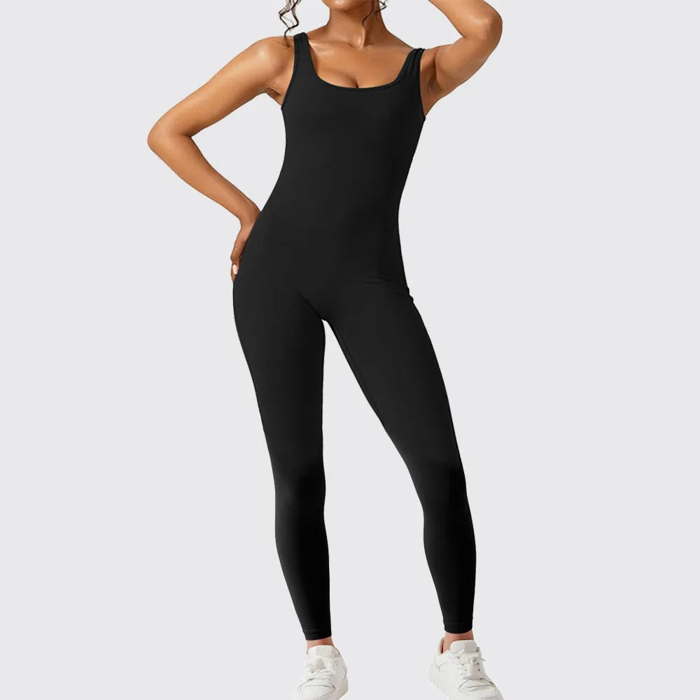 Woman wearing a sleeveless army green flare jumpsuit for yoga, showcasing the fashionable waist and trouser length.