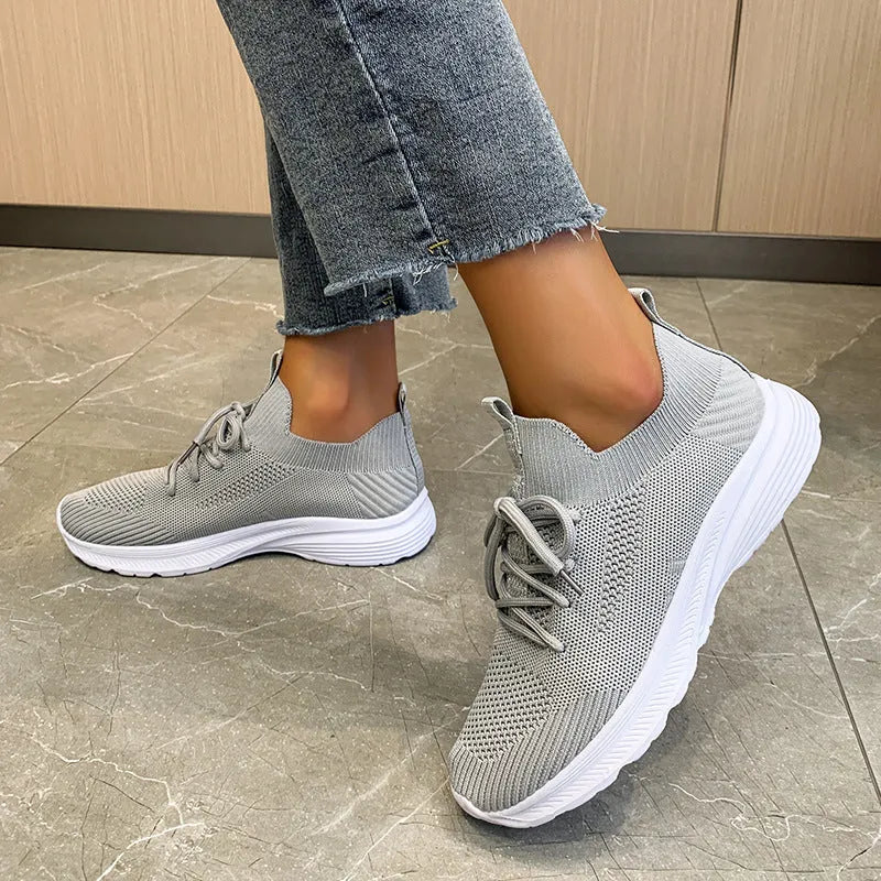 Women's cream running shoes with breathable mesh upper and flat rubber sole