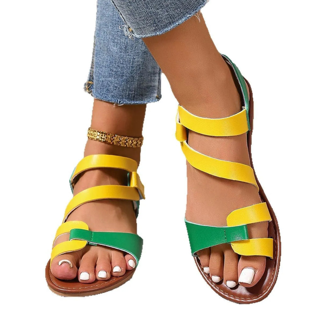 Women's flat sandals with Velcro strap, round toe, and PU upper in colourful, brown, or black.